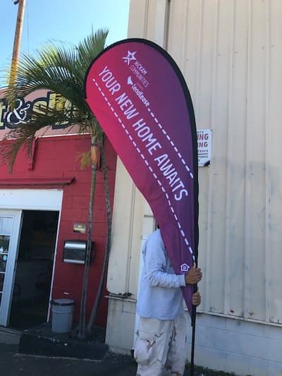 Hickam Communities teardrop flag reading Your New Home Awaits