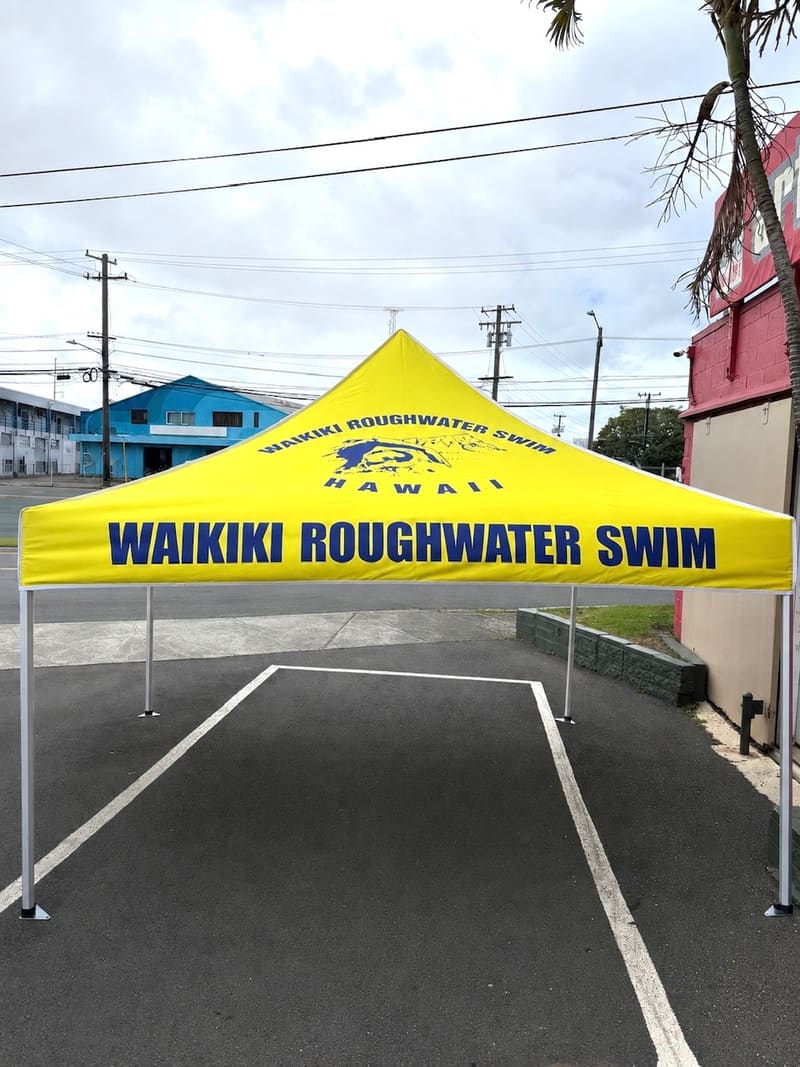 Waikiki Roughwater Swim yellow pop-up canopy tent with a printed valance