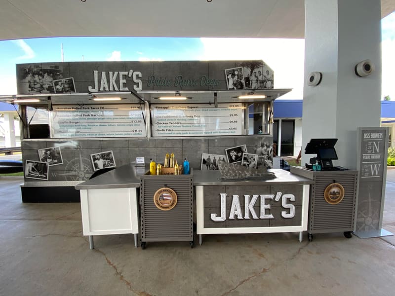 Jake's food kiosk wrapped with black-and-white photo graphics and menu panels