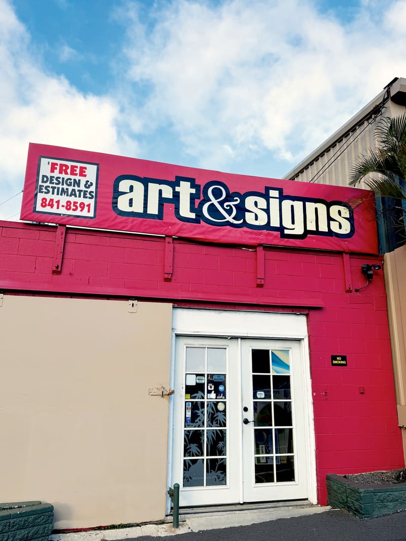 The Art & Signs storefront on Colburn Street in Honolulu, with its illuminated shop sign